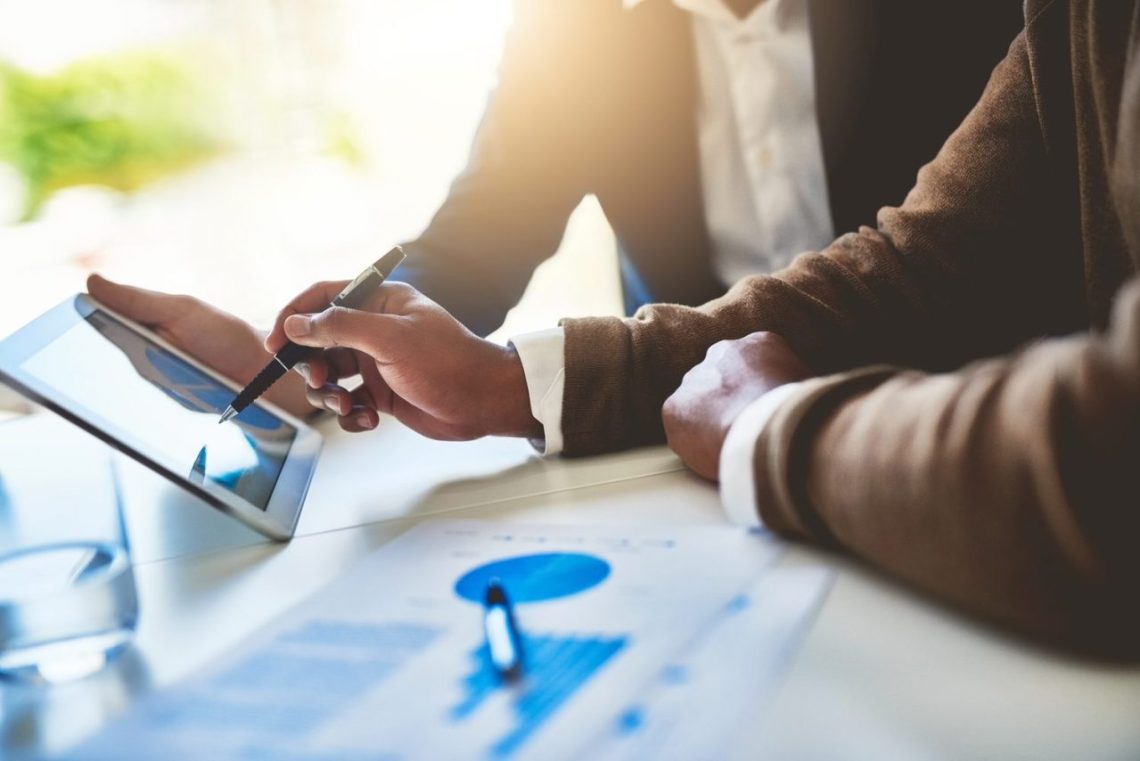 Conseiller financier et client analysant un plan de placement à trois ans autour d’une table.