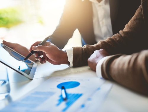 Conseiller financier et client analysant un plan de placement à trois ans autour d’une table.