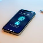 Smartphone affichant une interface abstraite de récupération sécurisée avec un cadenas lumineux et une empreinte biométrique.