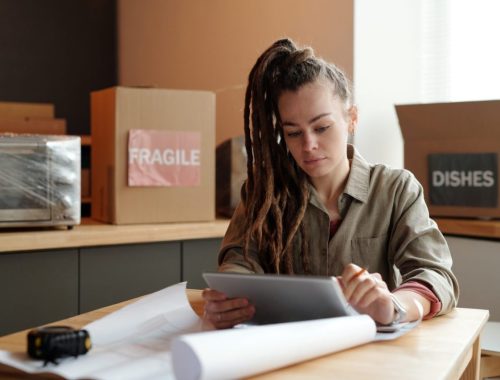Entrepreneur du e-commerce examine des contrats de fournisseurs européens devant un ordinateur.